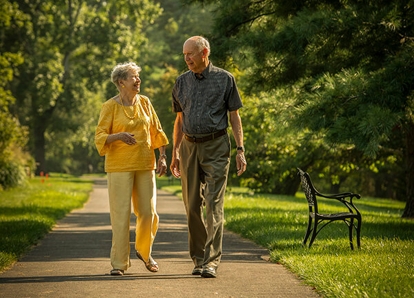 Happy older couple walking through campus